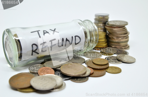 Image of Tax refund lable in a glass jar with coins spilling out