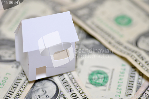 Image of Miniature paper made house stand on  money