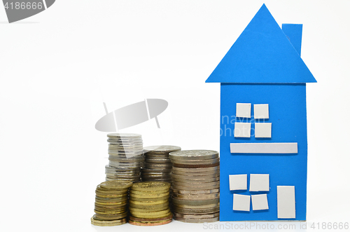 Image of House model and stacks of coins