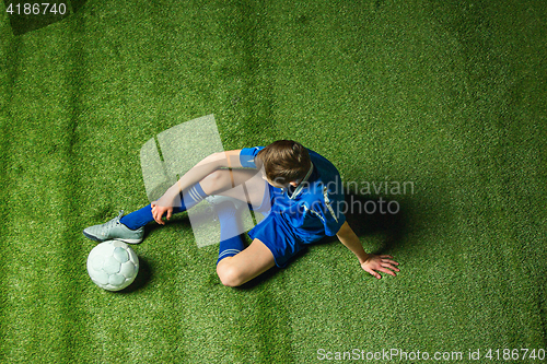 Image of Boy soccer player sitting on greeb grass