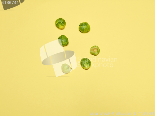 Image of The piles of Brussels sprouts on a yellow background