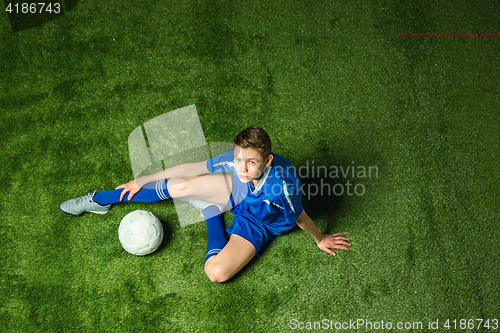 Image of Boy soccer player sitting on greeb grass