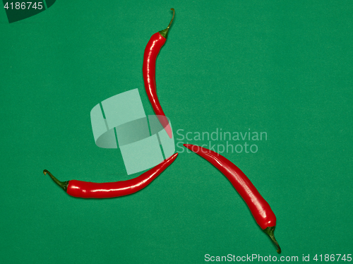 Image of bitter chili pepper and paprika on a green background