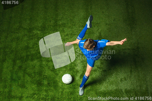 Image of Young boy with soccer ball doing flying kick