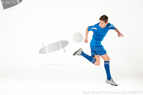 Image of Young boy with soccer ball doing flying kick