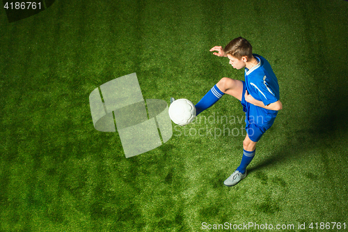 Image of Young boy with soccer ball doing flying kick