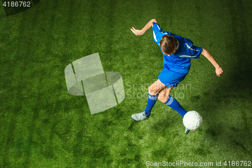 Image of Young boy with soccer ball doing flying kick