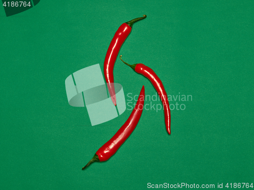 Image of bitter chili pepper and paprika on a green background