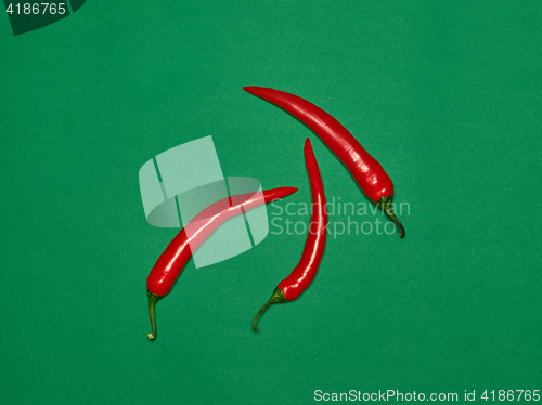 Image of bitter chili pepper and paprika on a green background