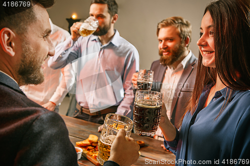 Image of Group of friends enjoying evening drinks with beer