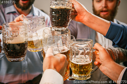 Image of Group of friends enjoying evening drinks with beer