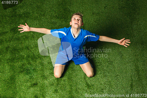 Image of Boy soccer player sitting on green grass