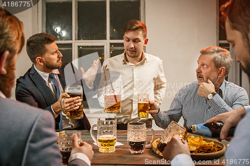 Image of Group of friends enjoying evening drinks with beer