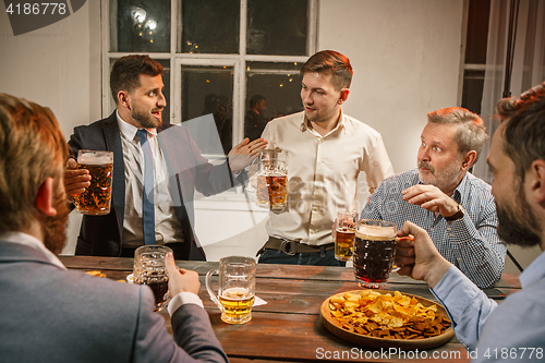 Image of Group of friends enjoying evening drinks with beer