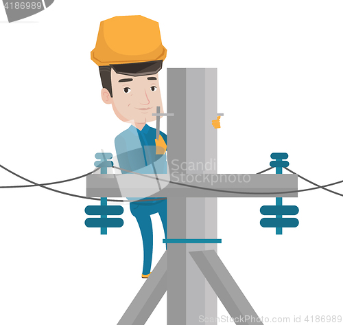 Image of Electrician working on electric power pole.