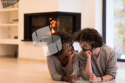 Image of multiethnic couple used tablet computer on the floor