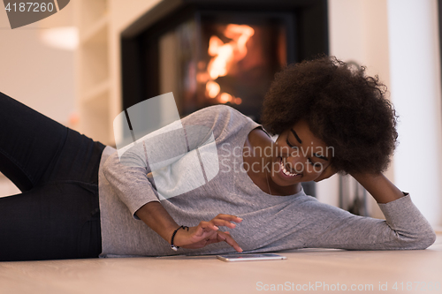 Image of black women used tablet computer on the floor