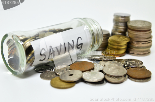 Image of Saving lable in a glass jar with coins spilling out