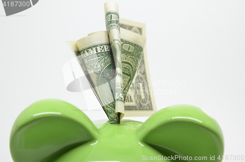 Image of Green piggy bank with US dollar bills 