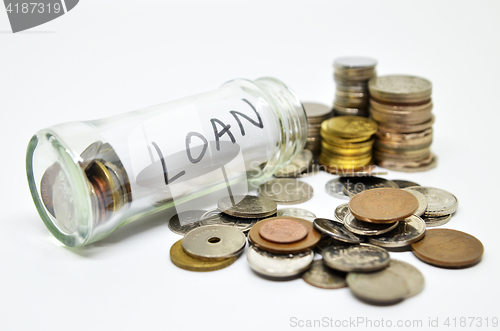 Image of Loan lable in a glass jar with coins spilling out