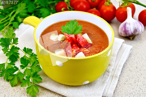 Image of Soup tomato in yellow bowl on granite table