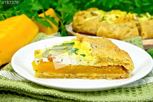 Image of Pie of pumpkin and cheese in white plate on dark board