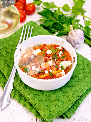Image of Shrimp and tomato with feta cheese in bowl on board