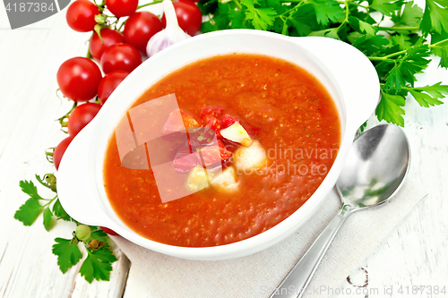 Image of Soup tomato in white bowl with vegetables on board