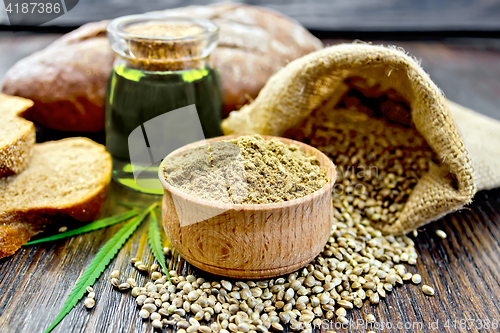 Image of Flour hemp in bowl with bread and oil on dark board