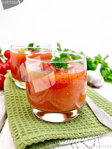 Image of Soup tomato in two glasses with parsley on light board