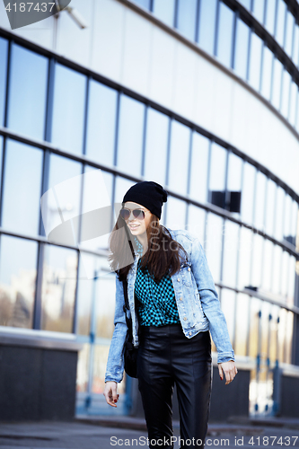 Image of young pretty girl near business building walking