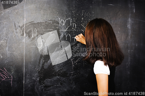 Image of portrait of happy cute student in classroom at blackboard back t