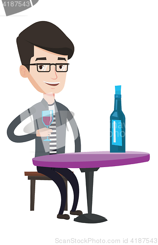 Image of Man drinking wine at restaurant.