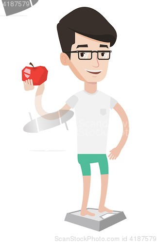 Image of Man standing on scale and holding apple in hand.