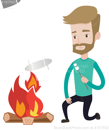 Image of Man roasting marshmallow over campfire.