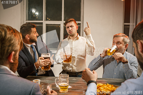 Image of Group of friends enjoying evening drinks with beer