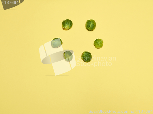 Image of The piles of Brussels sprouts on a yellow background