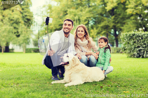 Image of happy family with dog taking selfie by smartphone