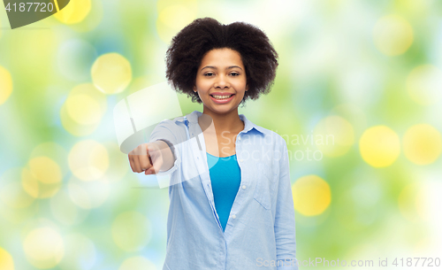 Image of happy african woman pointing finger to you