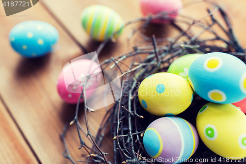 Image of close up of colored easter eggs in nest on wood