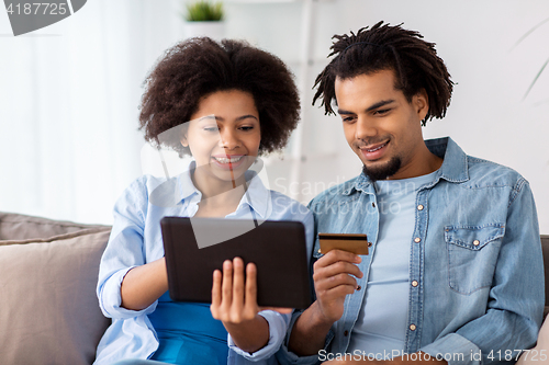 Image of couple with tablet pc and credit card at home