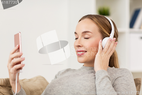 Image of woman with smartphone and headphones at home