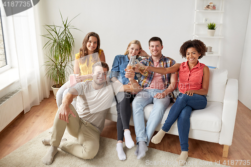 Image of happy friends with popcorn and beer at home