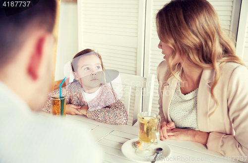 Image of happy family having dinner at restaurant or cafe