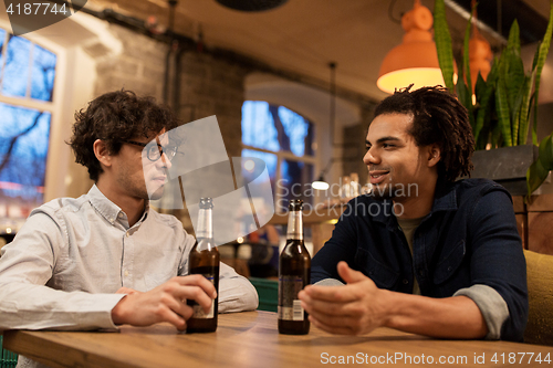 Image of happy male friends drinking beer at bar or pub