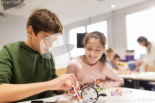 Image of happy children building robots at robotics school