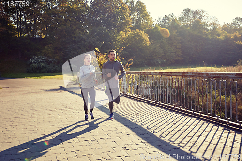 Image of happy couple running outdoors