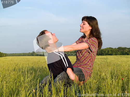 Image of Young man Holding Wife in Field Smiling