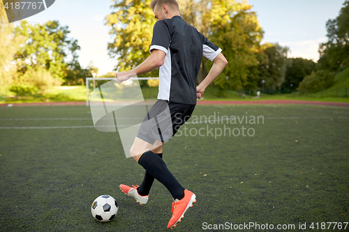 Image of soccer player playing with ball on football field
