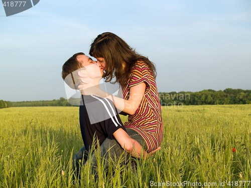 Image of Teen Couple Kissing in Field